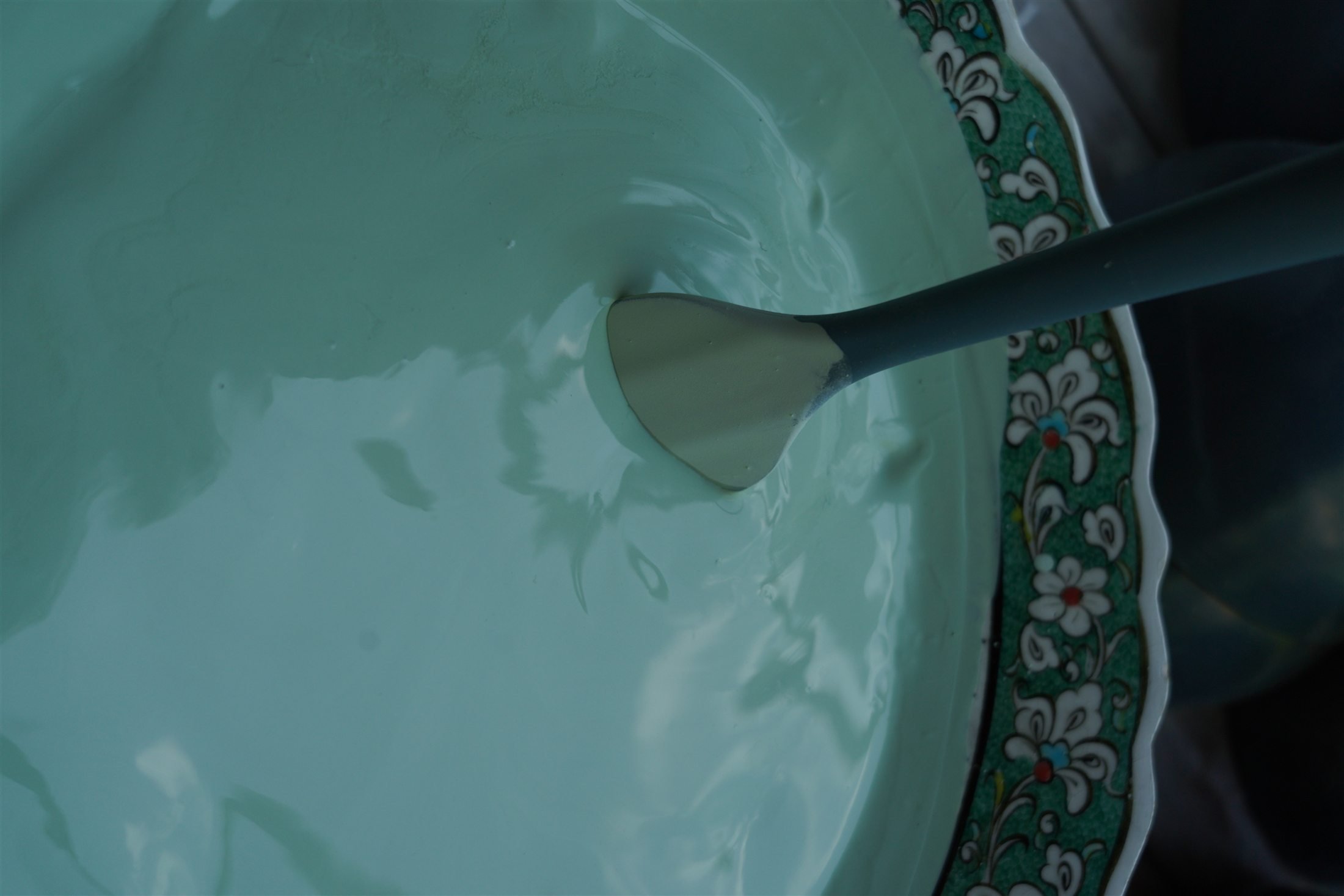 Aqua ceramic glaze being prepared by hand in the atelier.