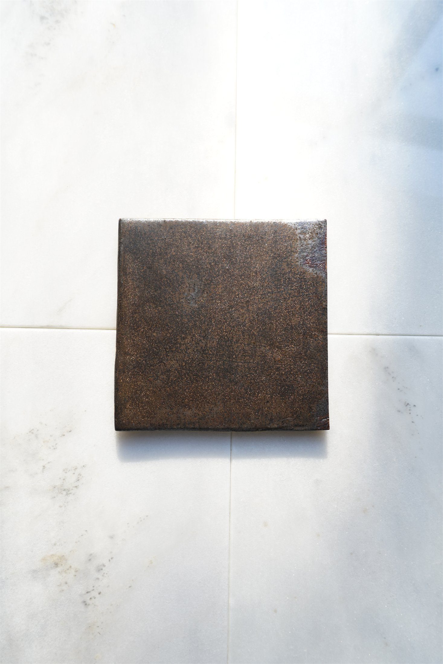 Mineral bronze surface with darker metallic depth.