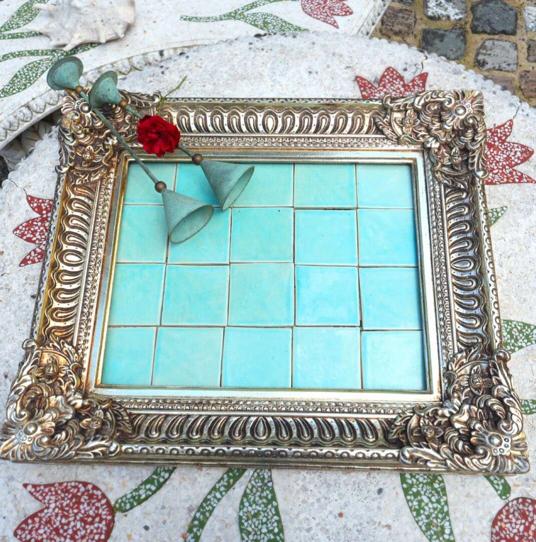 Pale turquoise handmade ceramic tiles presented in an ornate frame.