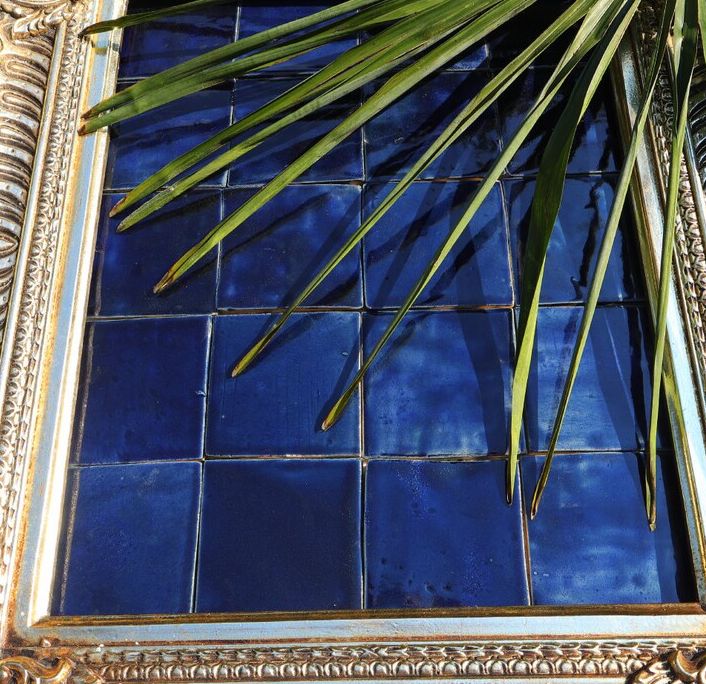 Cobalt handmade tiles presented in an ornate frame.