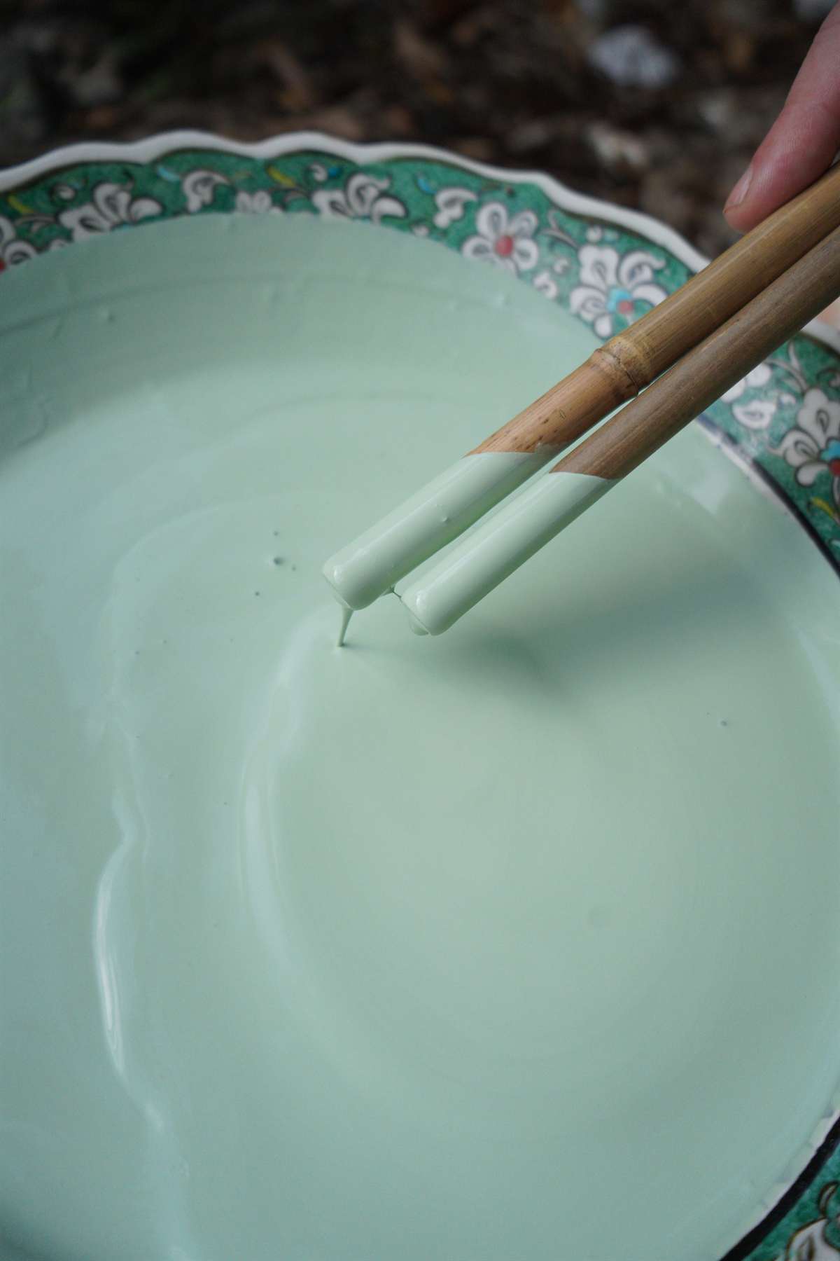 Glaze tools resting in a pale studio mixture.