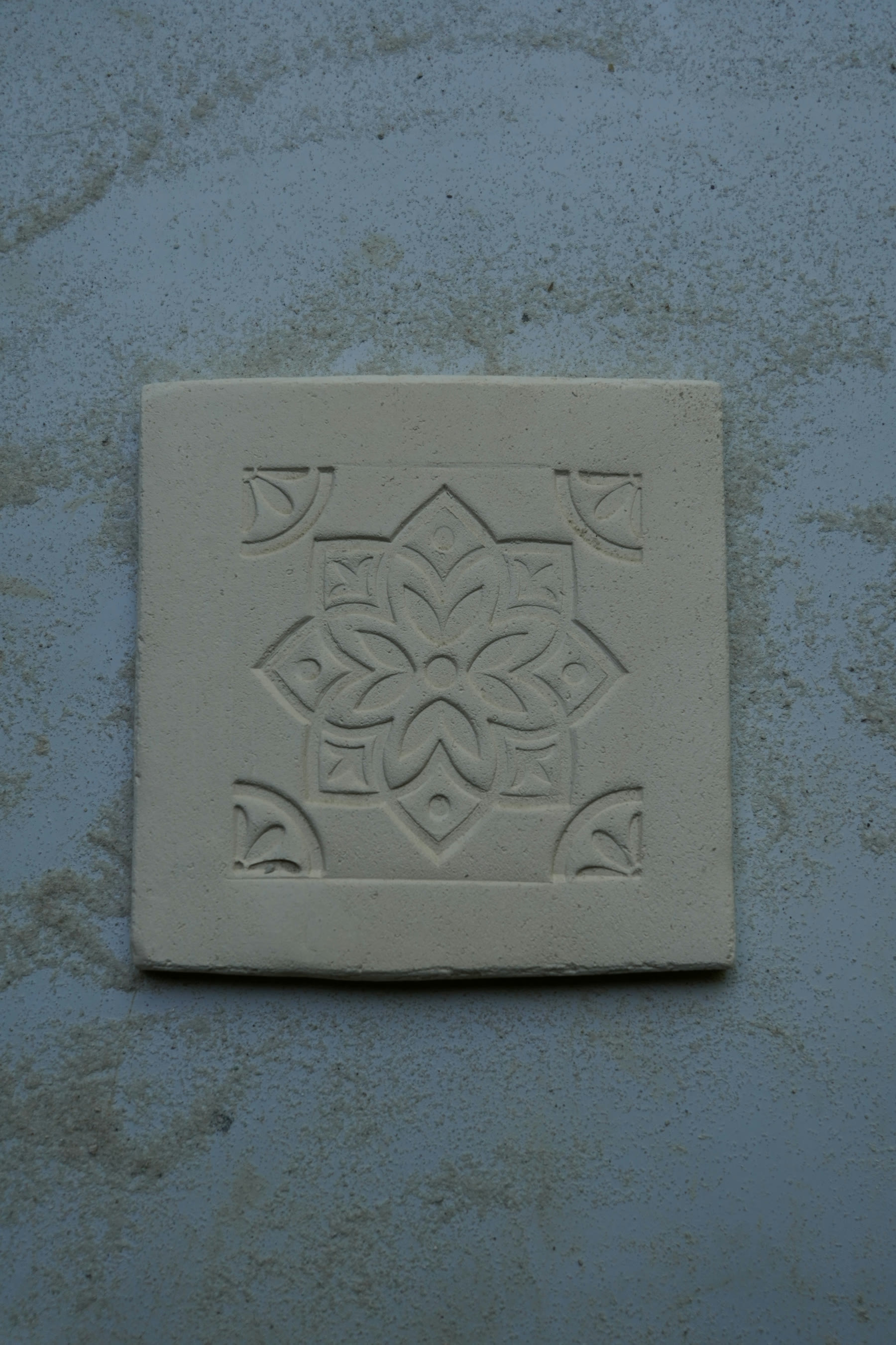 Raw relief tile with a Flemish-inspired pattern prepared before firing.