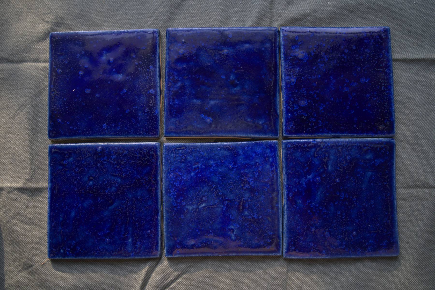 Six sapphire blue tiles showing glaze movement across a small field.