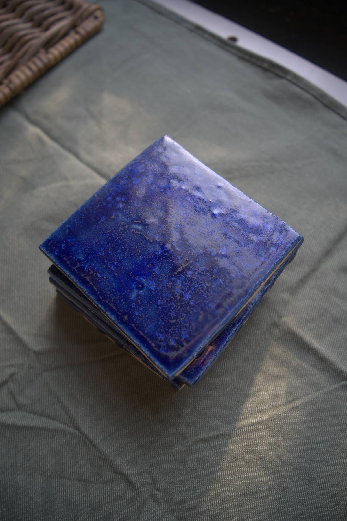 Stack of sapphire blue tiles with visible glaze depth.